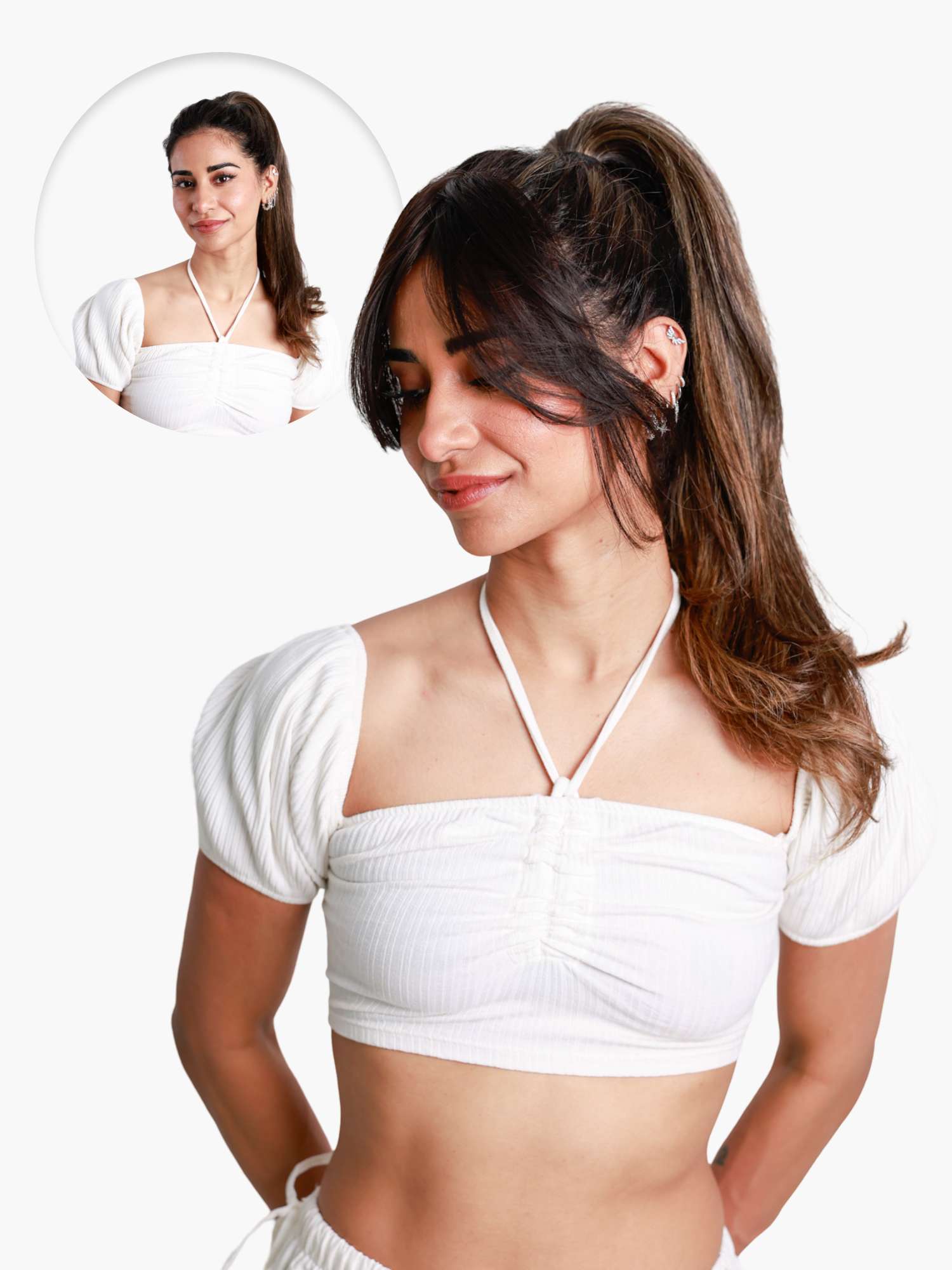 Woman with curtain bangs and a ponytail, wearing a white top.