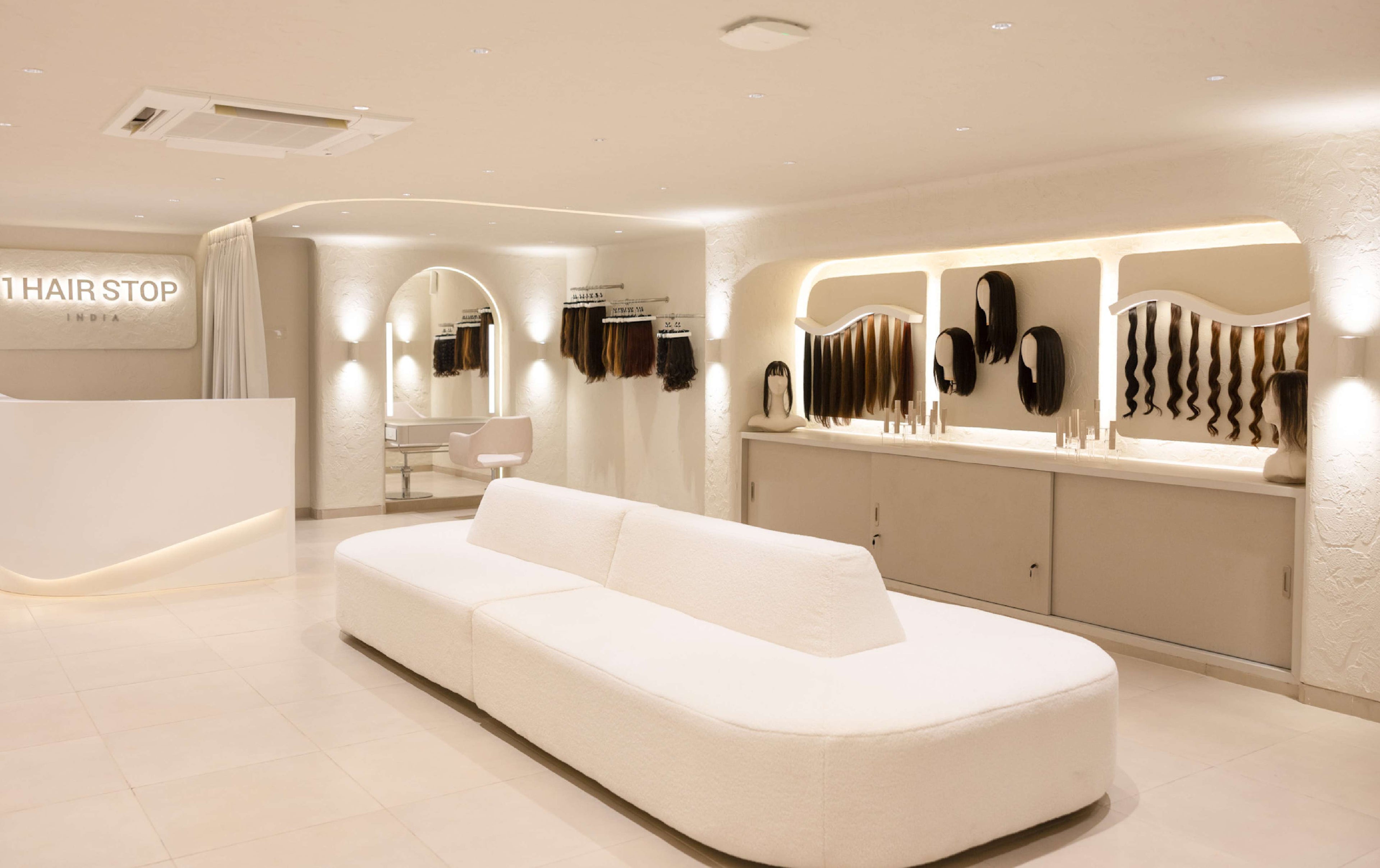 Luxurious hair salon interior displaying wigs and hair extensions on walls, with modern seating