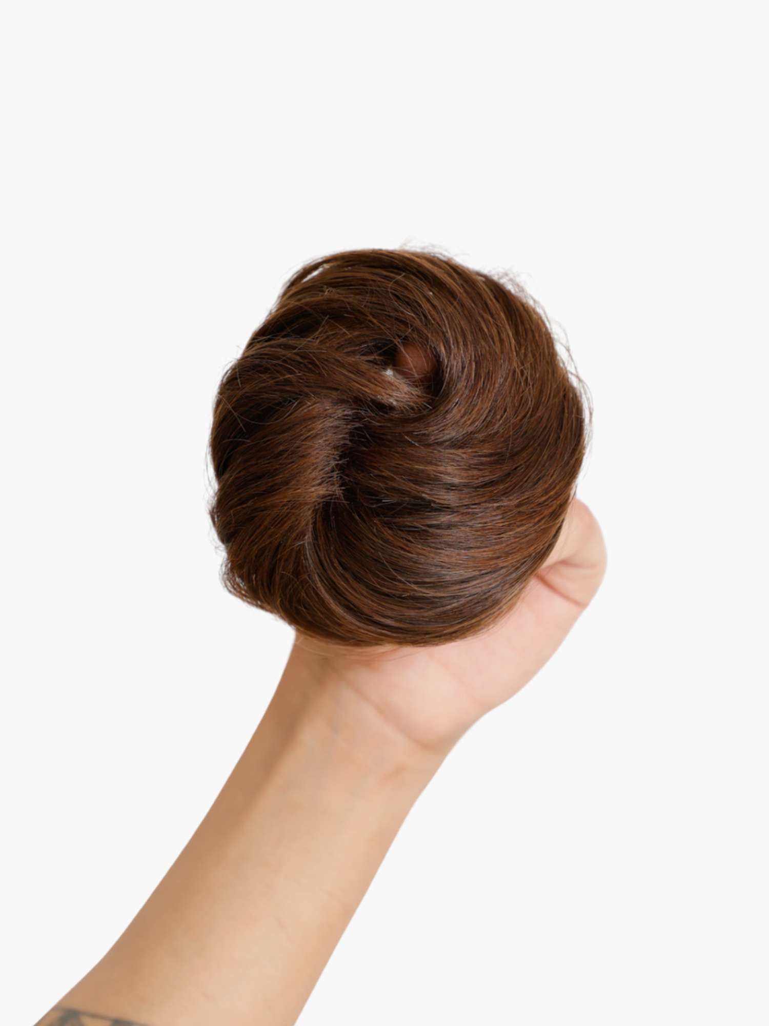 Hand holding a hair bun accessory, showing realistic texture and easy application