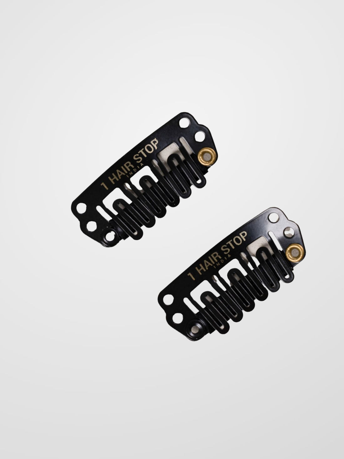 Two black hair extension clips with metal springs and snap closures.