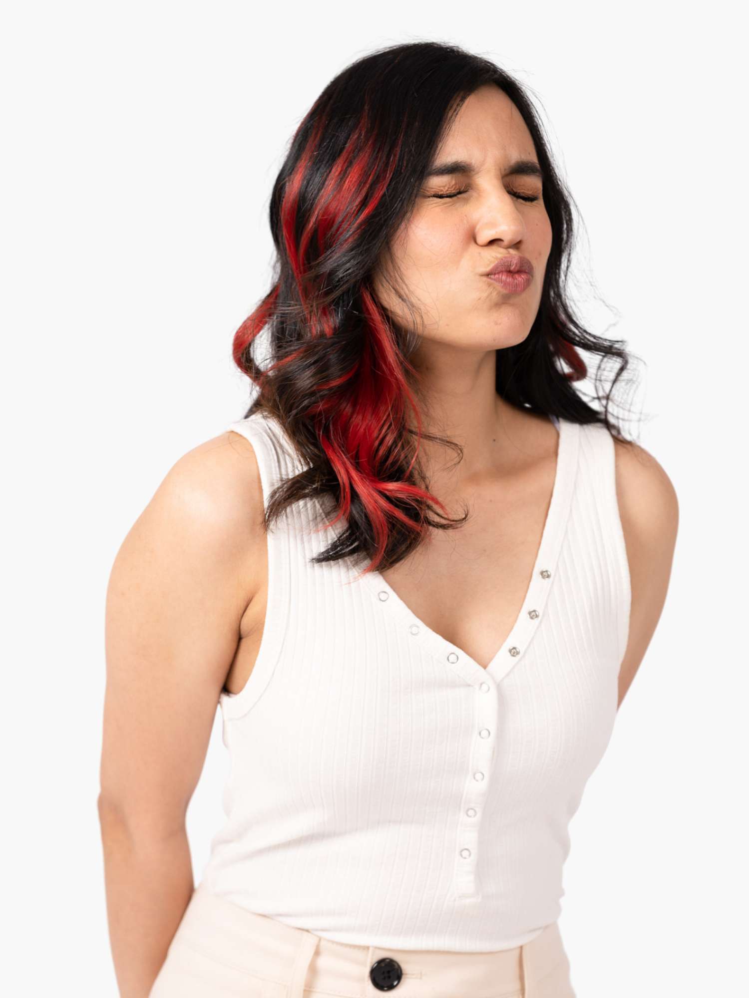 Woman with long wavy hair and red streaks, eyes closed, lips puckered.